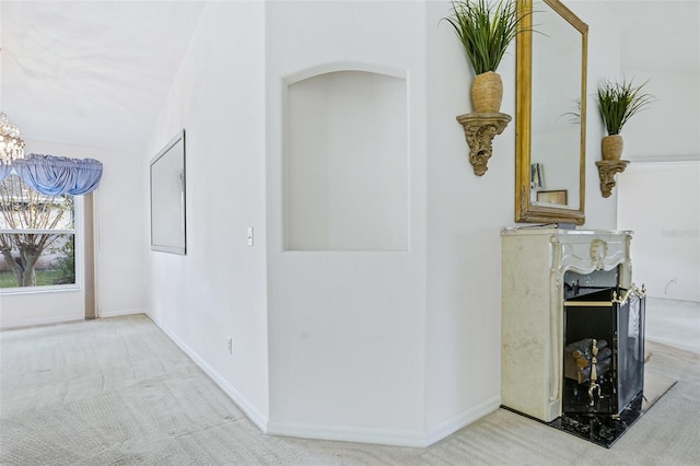 hallway featuring lofted ceiling and light carpet