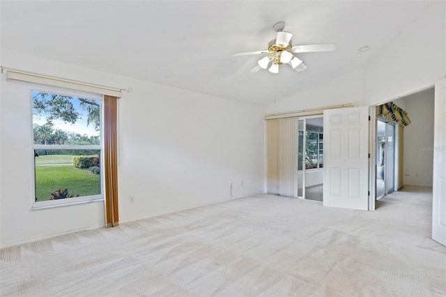 carpeted empty room featuring lofted ceiling, ceiling fan, and a wealth of natural light