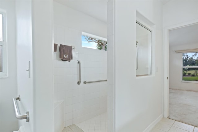 bathroom featuring a tile shower, tile patterned floors, and plenty of natural light