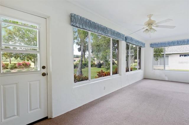 unfurnished sunroom with ceiling fan