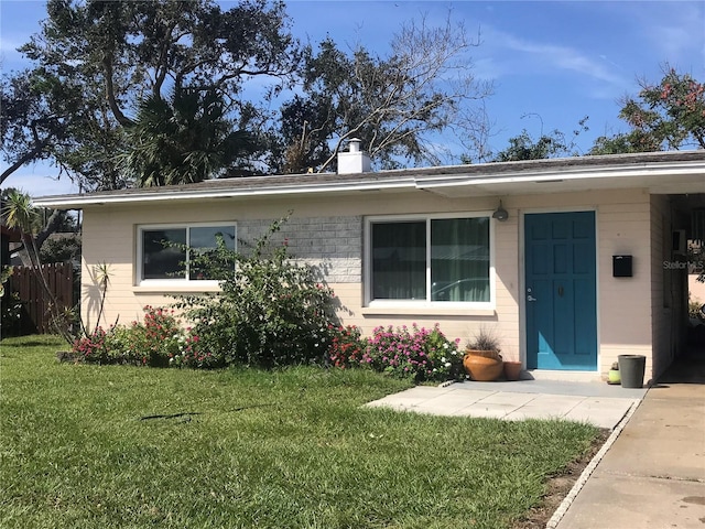 113 Neptune Dr, Edgewater, FL 32132 - view of front of property featuring brick siding, a chimney, a front yard, and fence