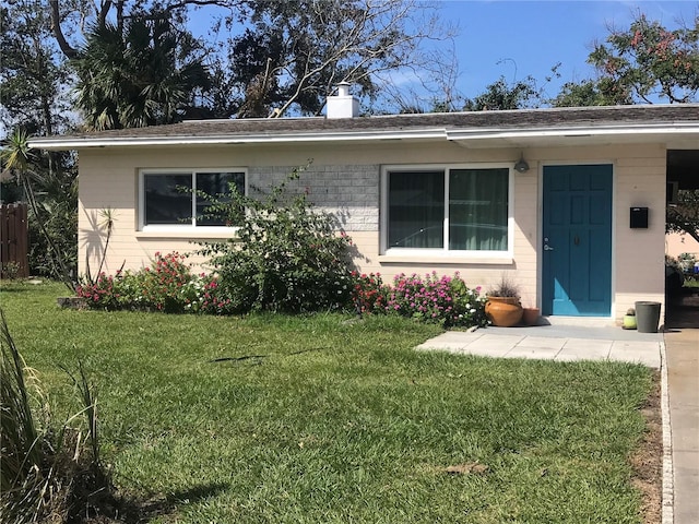 113 Neptune Dr, Edgewater, FL 32132 - view of front facade featuring brick siding, a chimney, and a front yard
