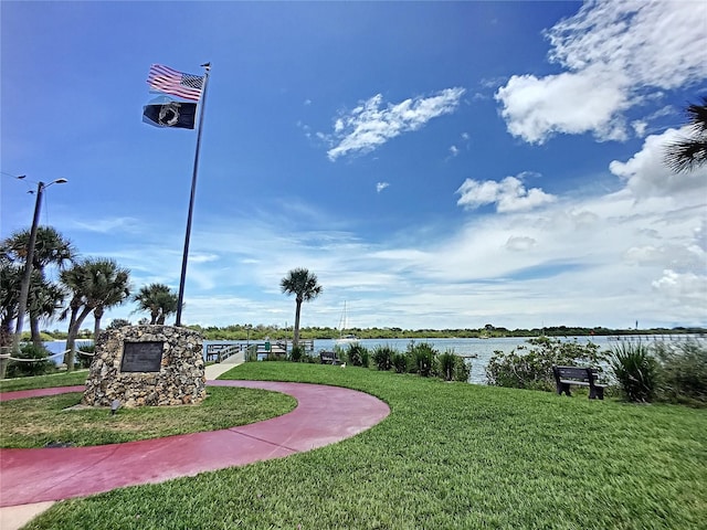 view of community featuring a lawn and a water view