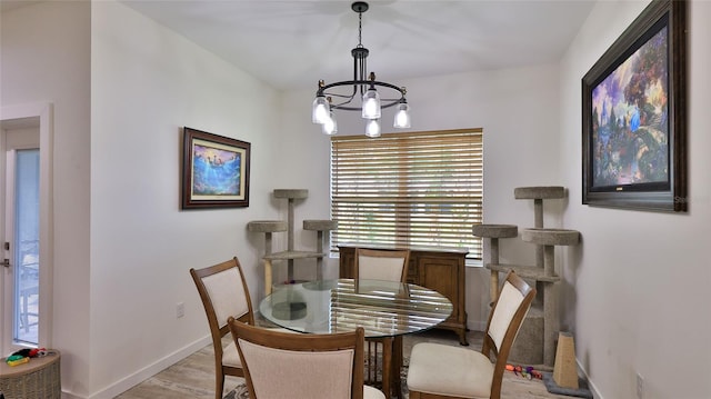 dining area featuring light hardwood / wood-style floors and an inviting chandelier