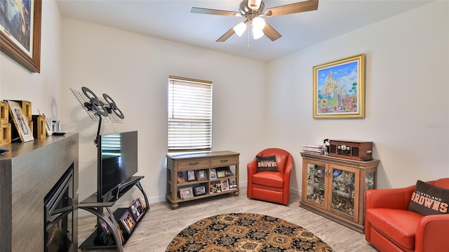 sitting room featuring light hardwood / wood-style floors and ceiling fan