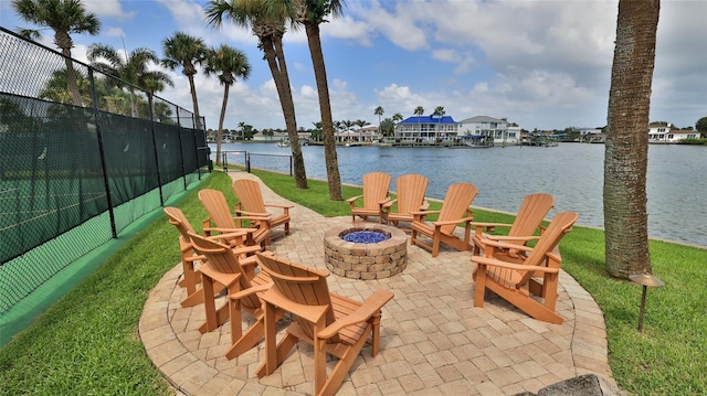 view of patio / terrace with a water view, an outdoor fire pit, and fence