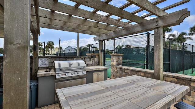 501 N Causeway Unit 2050, New Smyrna Beach, FL 32169 - view of patio with a grill, an outdoor kitchen, fence, and a pergola