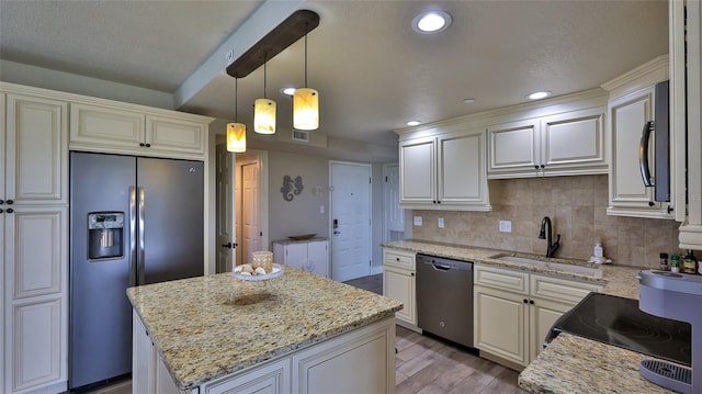 kitchen with stainless steel appliances, wood finished floors, a kitchen island, a sink, and backsplash