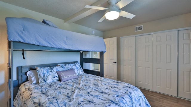 bedroom featuring ceiling fan, a closet, visible vents, and wood finished floors