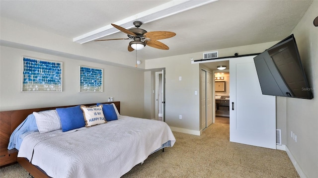 bedroom with light carpet, a barn door, visible vents, and baseboards