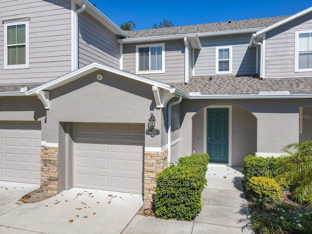679 Mount Olympus Blvd, New Smyrna Beach, FL 32168 - multi unit property featuring stone siding, a garage, driveway, stucco siding, and a shingled roof
