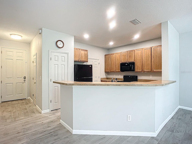 679 Mount Olympus Blvd, New Smyrna Beach, FL 32168 - kitchen featuring black appliances, light wood finished floors, baseboards, brown cabinets, and recessed lighting