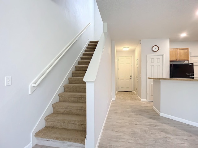 679 Mount Olympus Blvd, New Smyrna Beach, FL 32168 - stairs featuring wood finished floors and baseboards