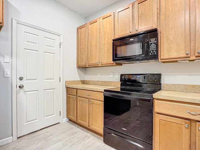 679 Mount Olympus Blvd, New Smyrna Beach, FL 32168 - kitchen with black appliances, light countertops, and light wood-type flooring