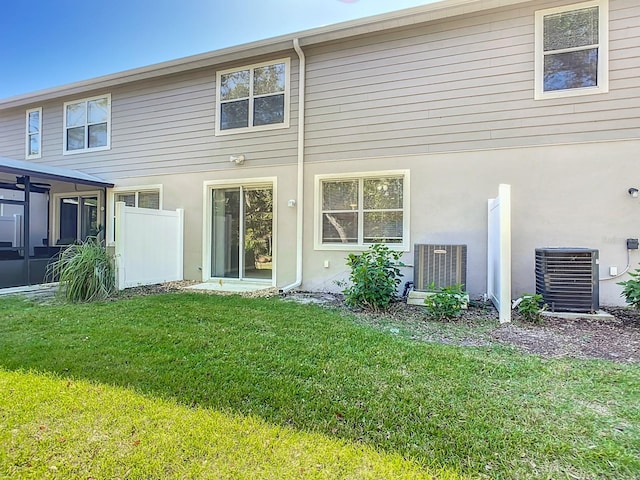 679 Mount Olympus Blvd, New Smyrna Beach, FL 32168 - back of house with a yard, central air condition unit, a sunroom, and stucco siding