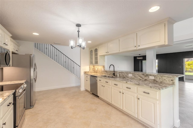 2266 Hawks Cove Cir, New Smyrna Beach, FL 32168 - kitchen with appliances with stainless steel finishes, a sink, a peninsula, a chandelier, and pendant lighting