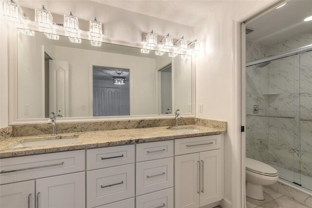 2266 Hawks Cove Cir, New Smyrna Beach, FL 32168 - full bathroom featuring marble look tile flooring, toilet, a marble finish shower, and double vanity