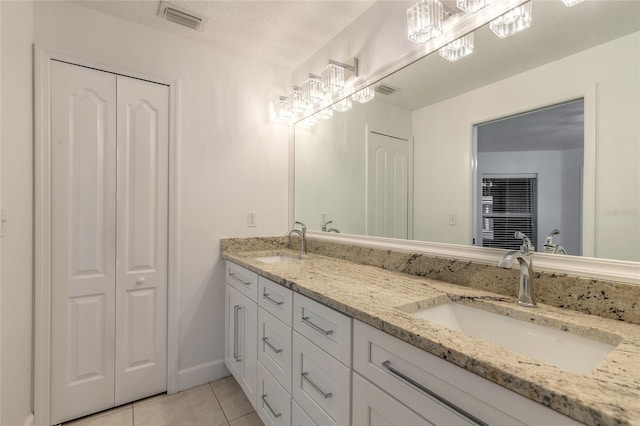 2266 Hawks Cove Cir, New Smyrna Beach, FL 32168 - full bath with tile patterned flooring, double vanity, a closet, and a chandelier