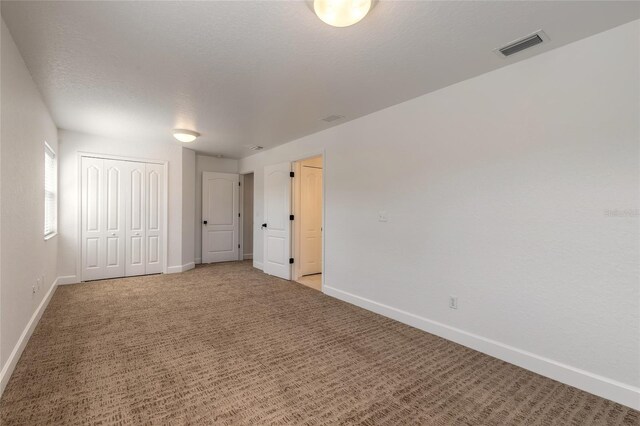 2266 Hawks Cove Cir, New Smyrna Beach, FL 32168 - unfurnished bedroom with baseboards, light colored carpet, and a closet