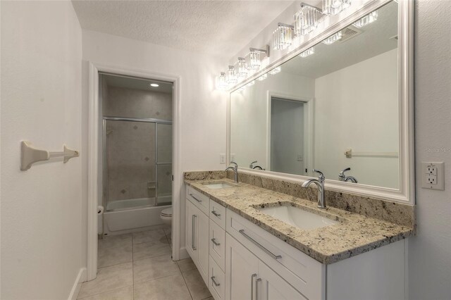 2266 Hawks Cove Cir, New Smyrna Beach, FL 32168 - bathroom featuring tile patterned flooring, double vanity, toilet, shower / bath combination with glass door, and baseboards