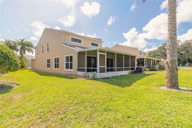 2266 Hawks Cove Cir, New Smyrna Beach, FL 32168 - rear view of property featuring a sunroom, stucco siding, a yard, and central AC unit
