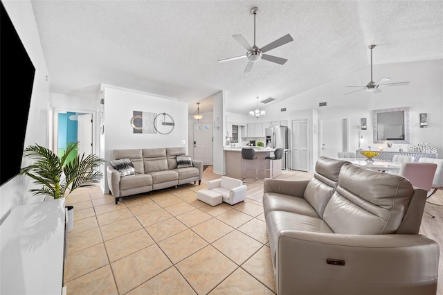 tiled living room featuring high vaulted ceiling, a textured ceiling, and ceiling fan with notable chandelier