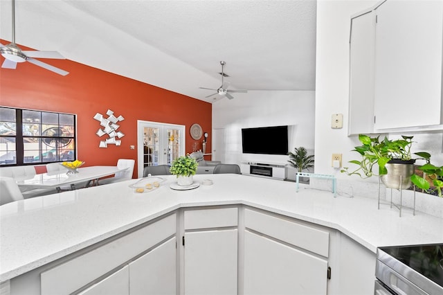 kitchen with lofted ceiling, white cabinets, french doors, and kitchen peninsula