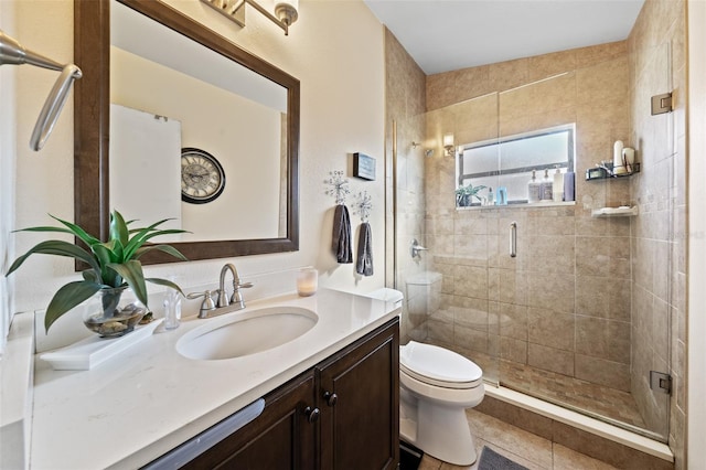 bathroom with vanity, a shower with shower door, toilet, and tile patterned floors