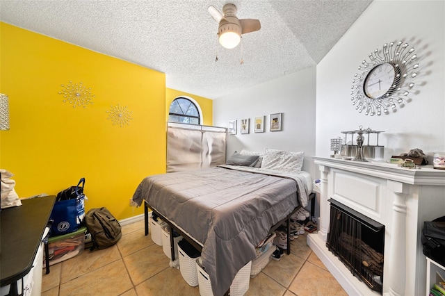 bedroom with ceiling fan, a textured ceiling, and light tile patterned floors