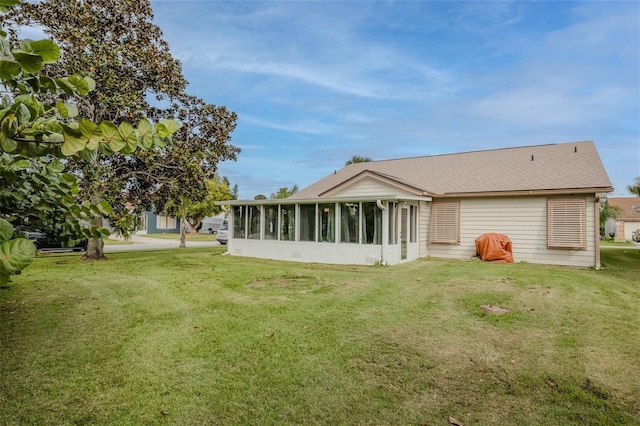 back of property featuring a sunroom and a yard