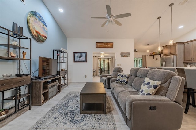 living room with ceiling fan, lofted ceiling, and light hardwood / wood-style floors