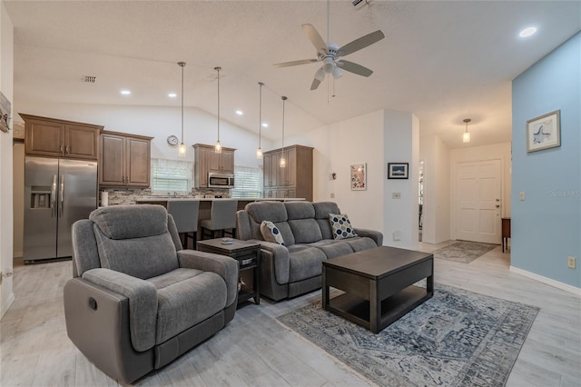 living room featuring light hardwood / wood-style floors, lofted ceiling, and ceiling fan