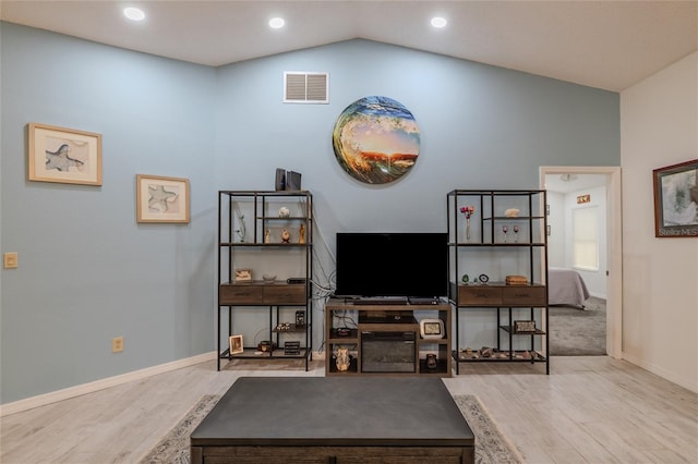 living room with light wood-type flooring and vaulted ceiling