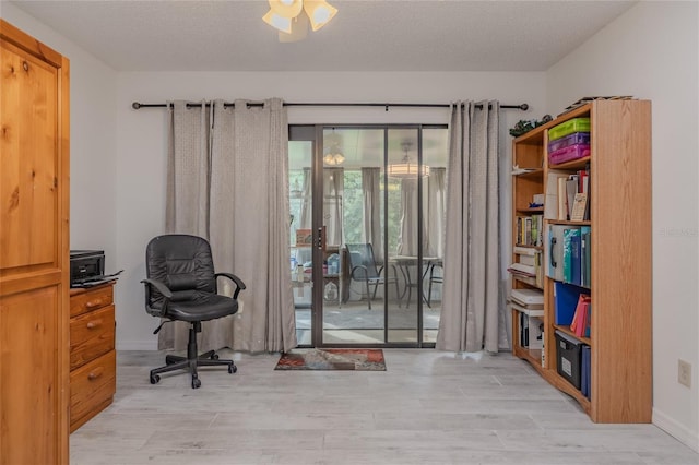 home office featuring a textured ceiling and light hardwood / wood-style flooring