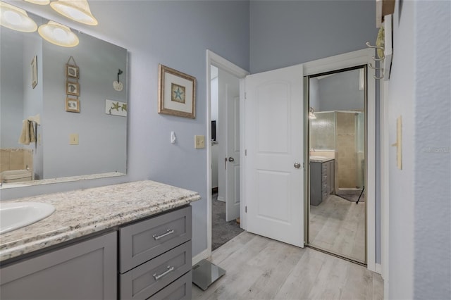 bathroom featuring an enclosed shower, vanity, and hardwood / wood-style flooring