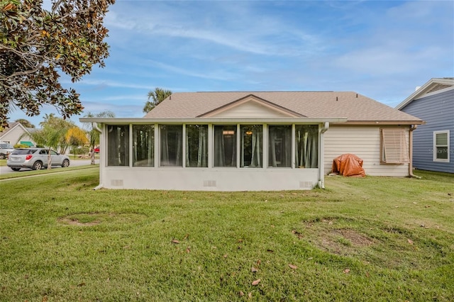 back of property featuring a sunroom and a yard