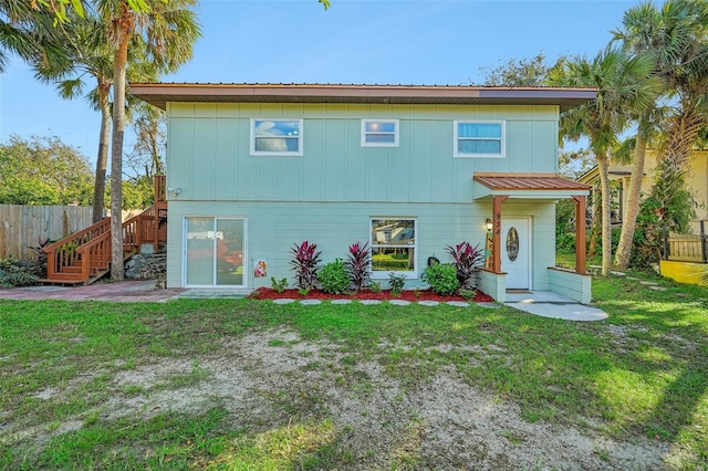 rear view of house featuring a yard