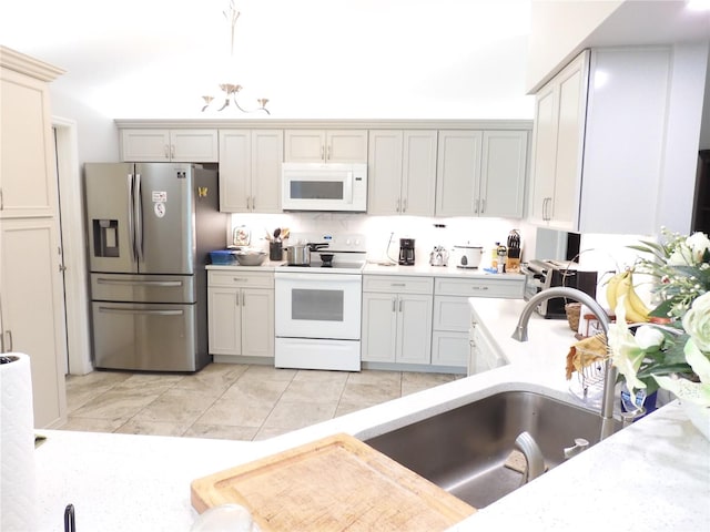 kitchen featuring tasteful backsplash, sink, light tile patterned floors, and white appliances