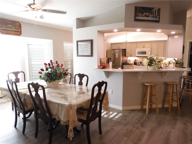 dining space featuring lofted ceiling, dark hardwood / wood-style floors, and ceiling fan