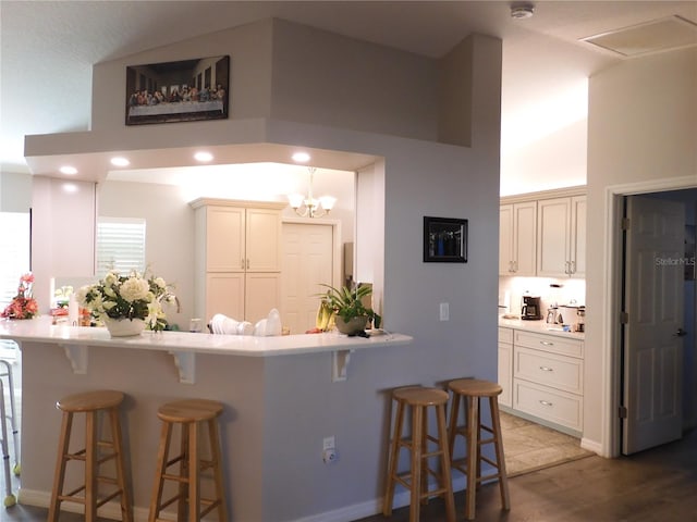 kitchen featuring a kitchen breakfast bar, kitchen peninsula, high vaulted ceiling, and light wood-type flooring