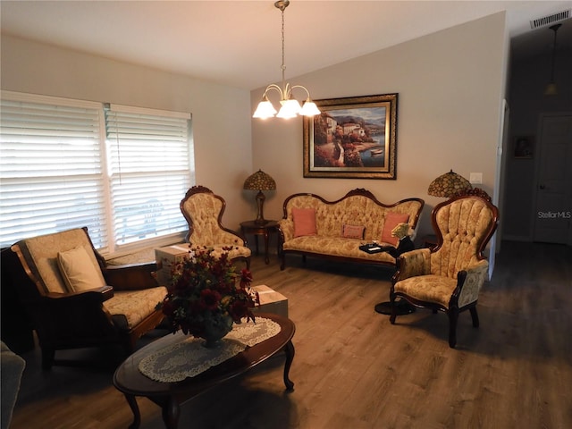 living room featuring wood-type flooring, vaulted ceiling, and an inviting chandelier