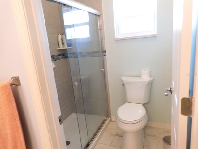 bathroom with toilet and a shower with shower door