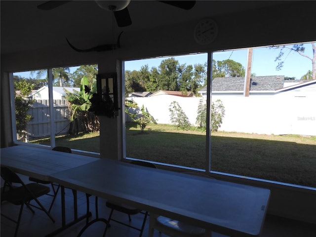 unfurnished sunroom featuring ceiling fan