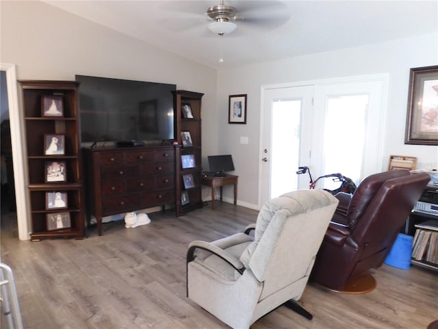 living room with lofted ceiling, hardwood / wood-style flooring, and ceiling fan