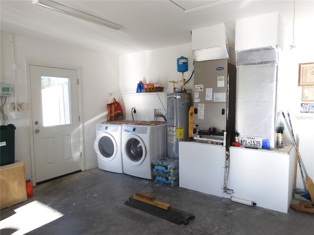 washroom with water heater and washing machine and clothes dryer