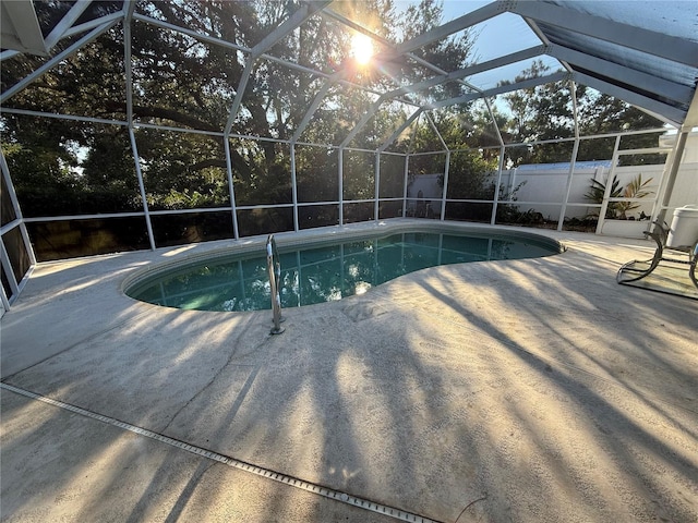 view of pool with glass enclosure and a patio area