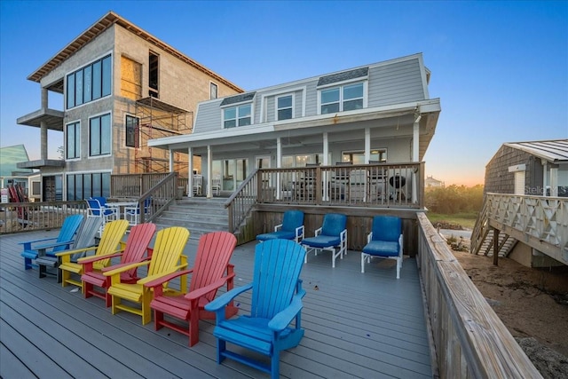 back house at dusk featuring a deck