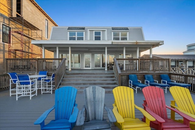 back house at dusk with a deck