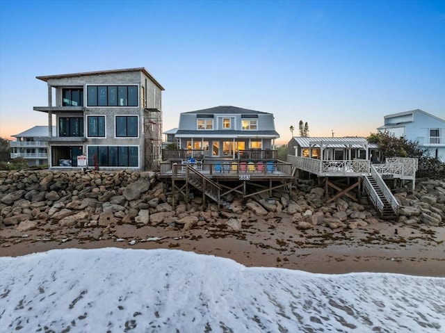 snow covered house featuring a wooden deck