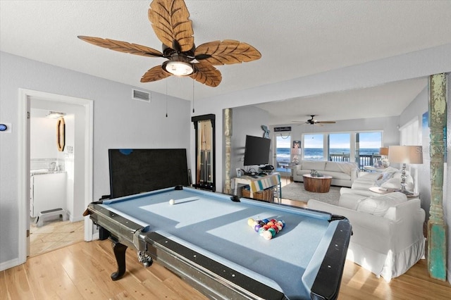 game room featuring ceiling fan, a textured ceiling, light hardwood / wood-style flooring, and pool table